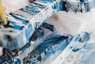 The process of creating a home-made trendy abstract modern pattern painted  with a brush of acrylic blue multi-colored resin on a round wooden boar  14273848 Stock Photo at Vecteezy